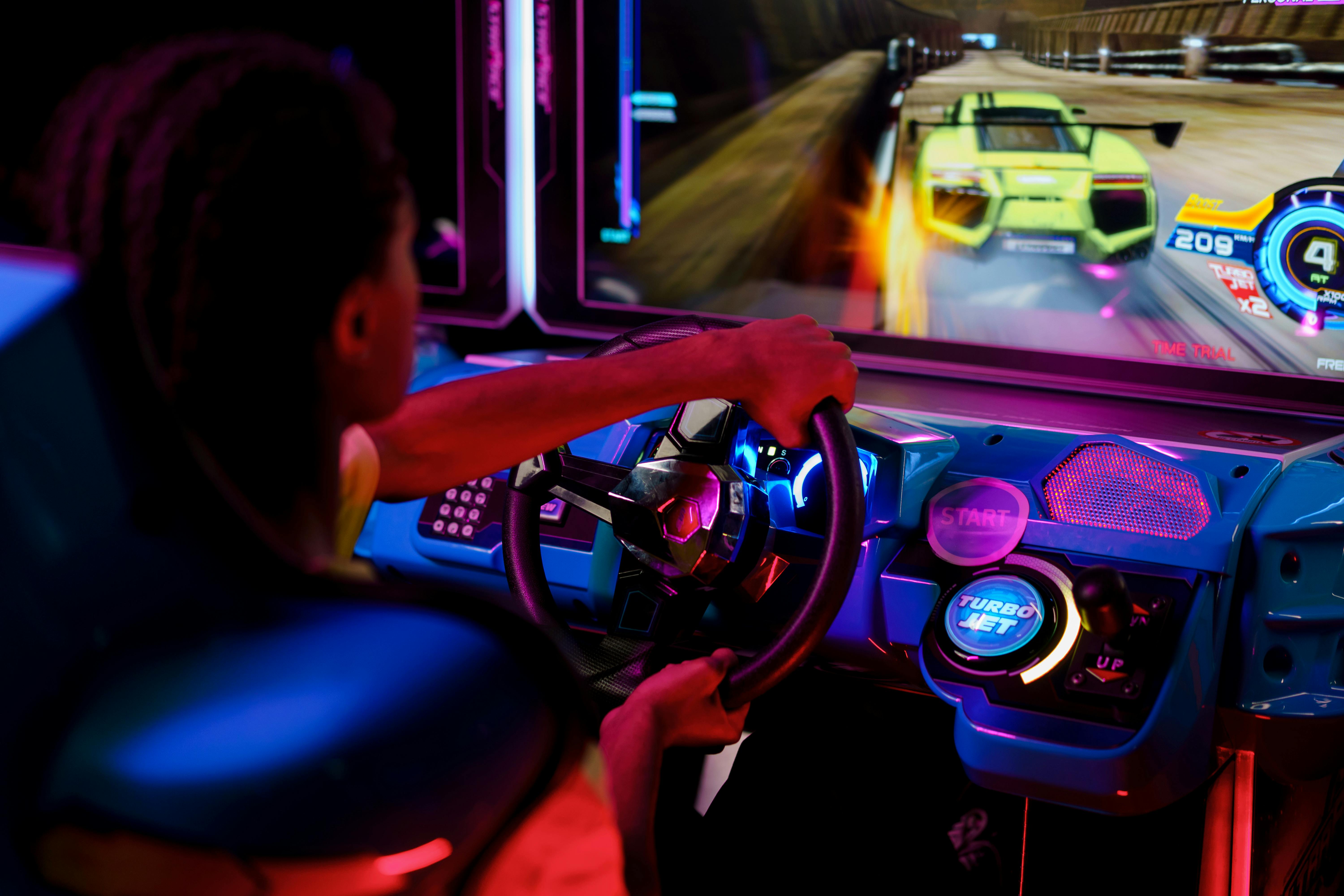 Man driving an arcade race car machina